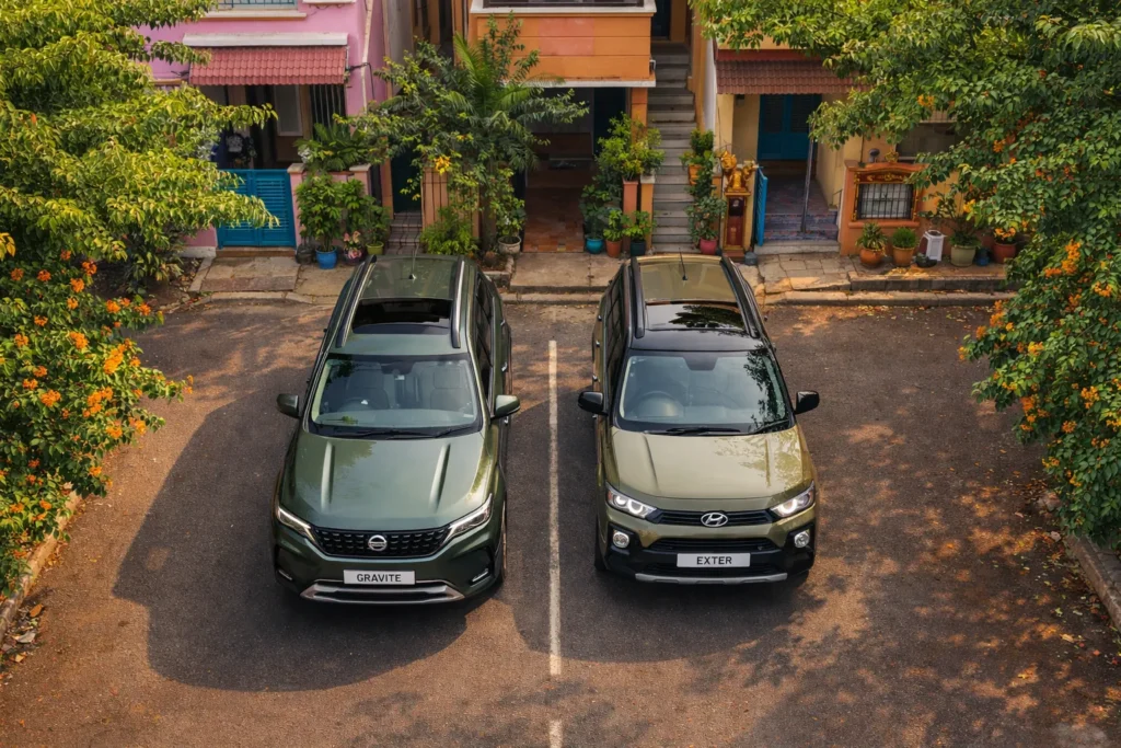 Drone overhead shot of Nissan Gravite and Hyundai Exter parked side by side in a colourful Indian neighbourhood street with trees